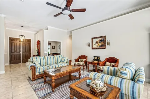 a living room with furniture a rug and a ceiling fan