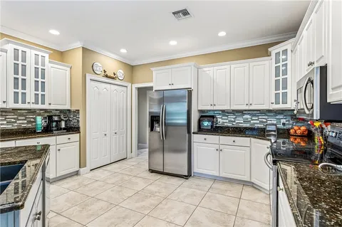 a kitchen with stainless steel appliances granite countertop a refrigerator and a stove top oven