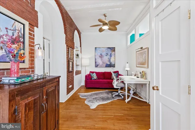 a living room with furniture and paintings on the wall
