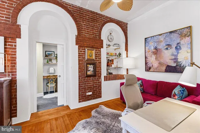 a living room with furniture a rug and wall paintings