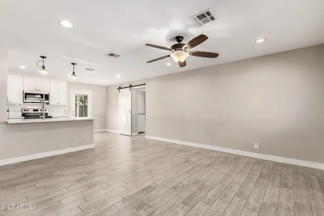 wooden floor in an empty room with a kitchen