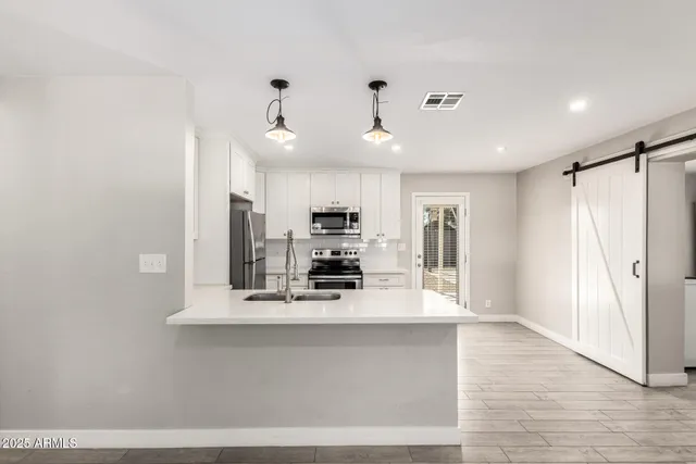 a view of kitchen with stainless steel appliances granite countertop a refrigerator and a sink
