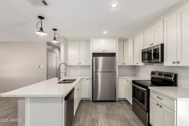 a kitchen with a sink a microwave a refrigerator and cabinets