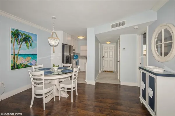 a view of a dining room with furniture a chandelier and wooden floor