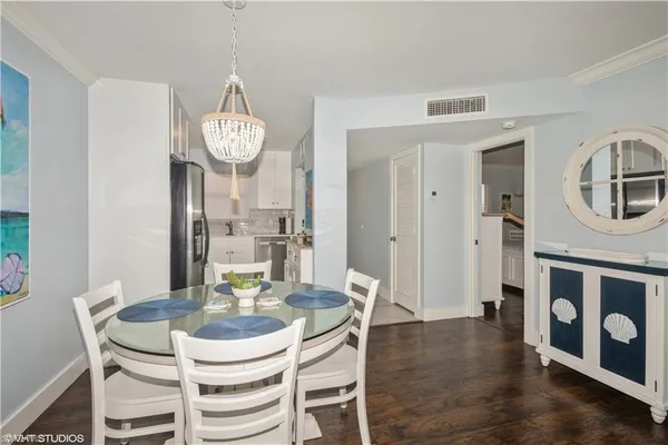 a view of a dining room with furniture a chandelier and wooden floor