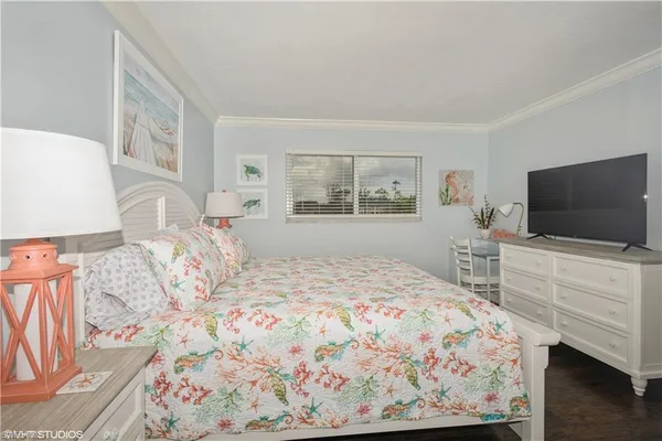 a bedroom with a bed and a flat screen tv in it