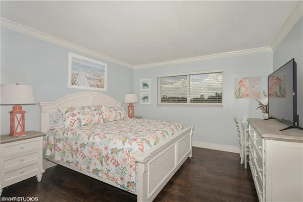 a bedroom with a bed and a tv on the dresser