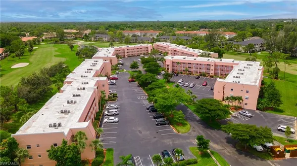 an aerial view of a city with lots of residential buildings ocean and mountain view in back