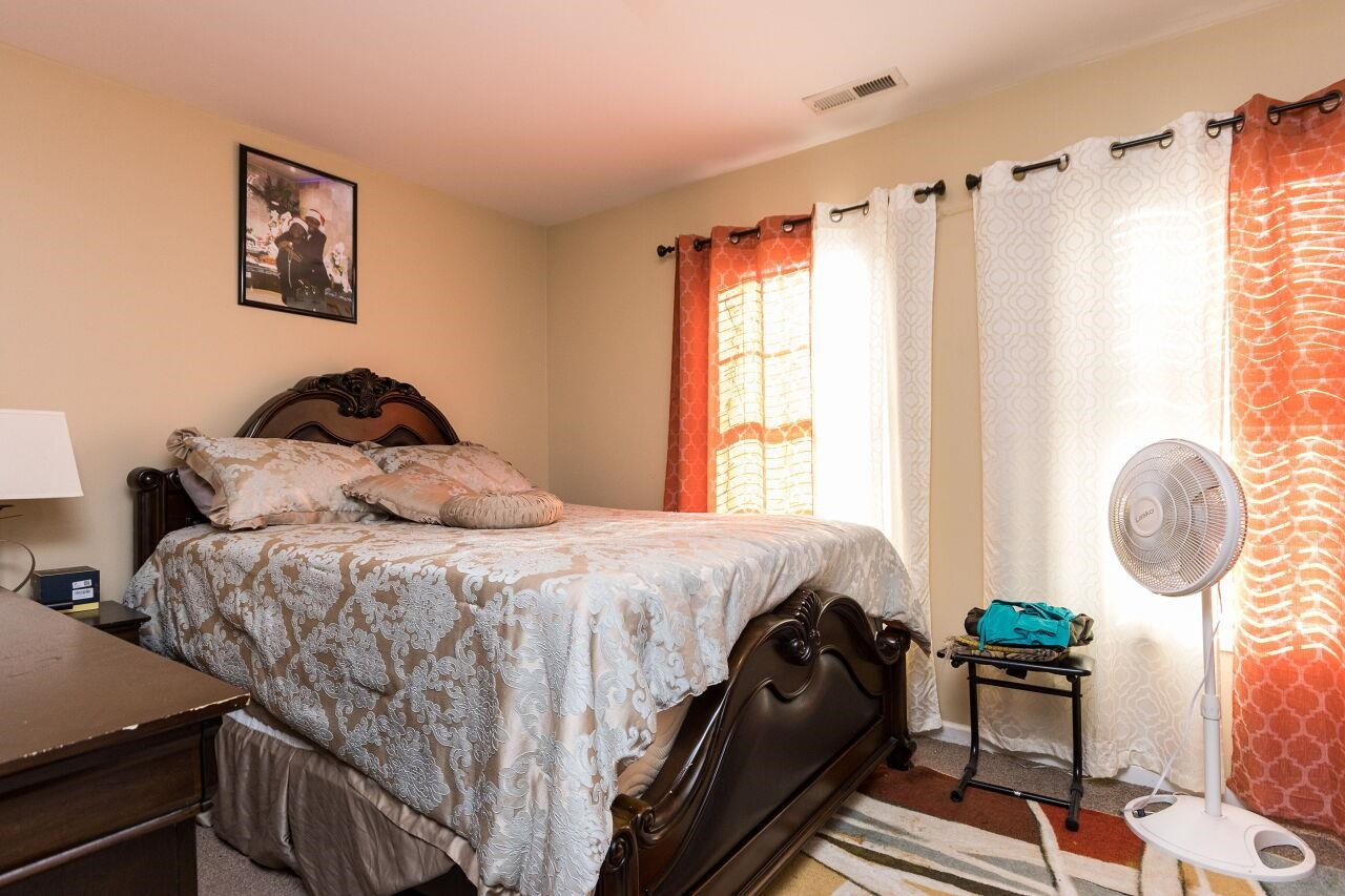 4802 Parkville Drive Raleigh, NC 27604 - Photo 12 of 15 a bedroom with a bed a dresser and next to a window