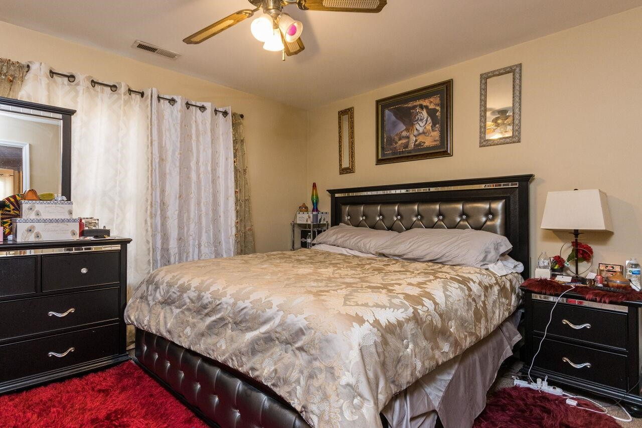 4802 Parkville Drive Raleigh, NC 27604 - Photo 10 of 15 a bedroom with a bed and a chandelier