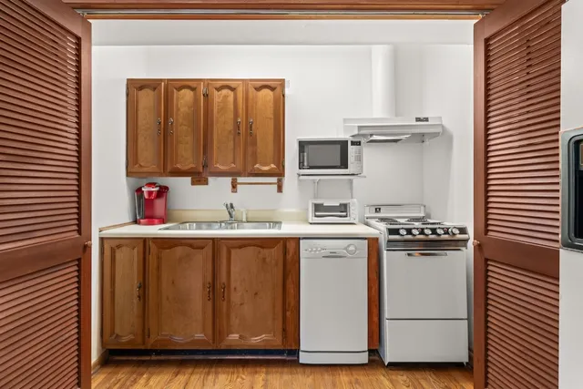 a view of empty room with wooden floor and ceiling fan