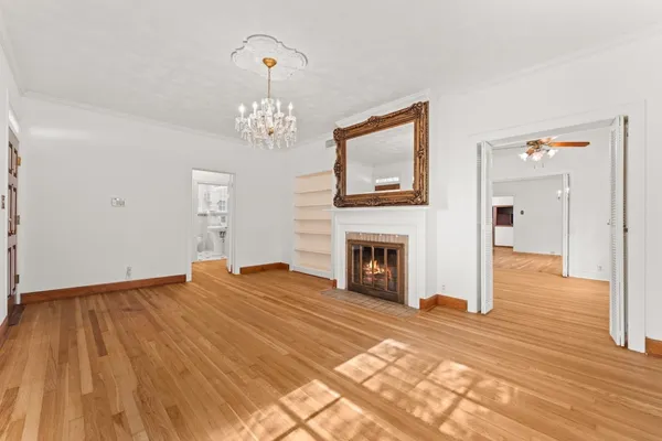 a view of a livingroom with wooden floor and a fireplace