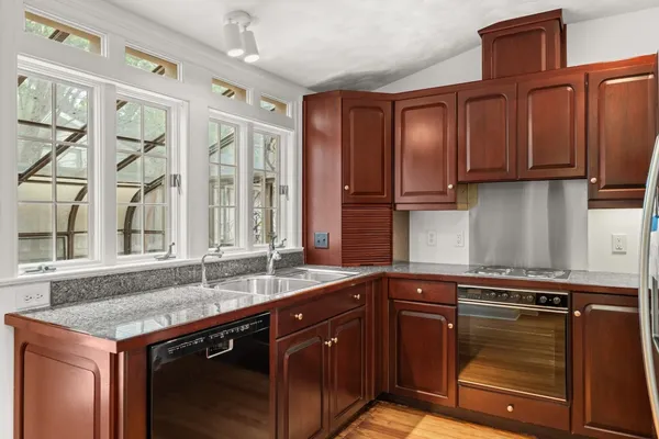 a kitchen with stainless steel appliances granite countertop a sink stove and cabinets