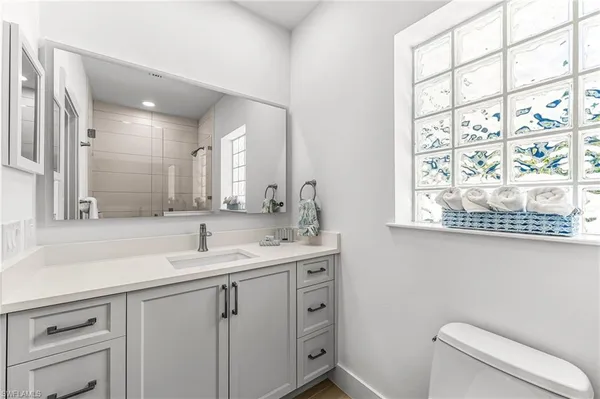 a bathroom with a toilet sink and mirror