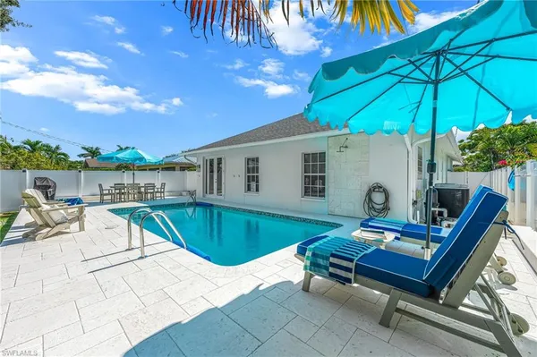 a roof deck with table and chairs under an umbrella