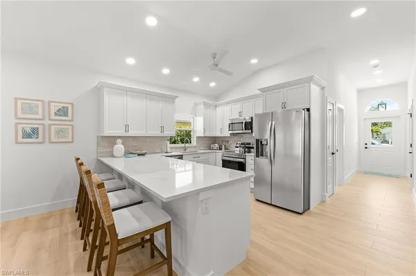 a kitchen with refrigerator and chairs