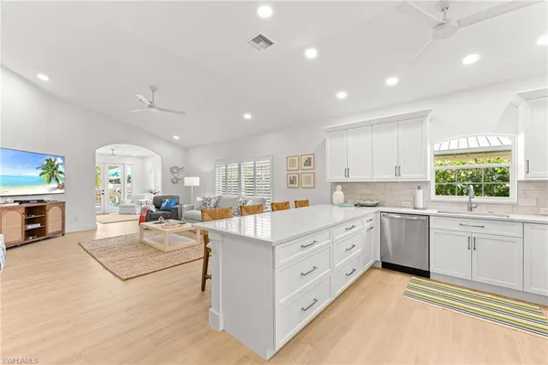 a large white kitchen with lots of counter space and windows
