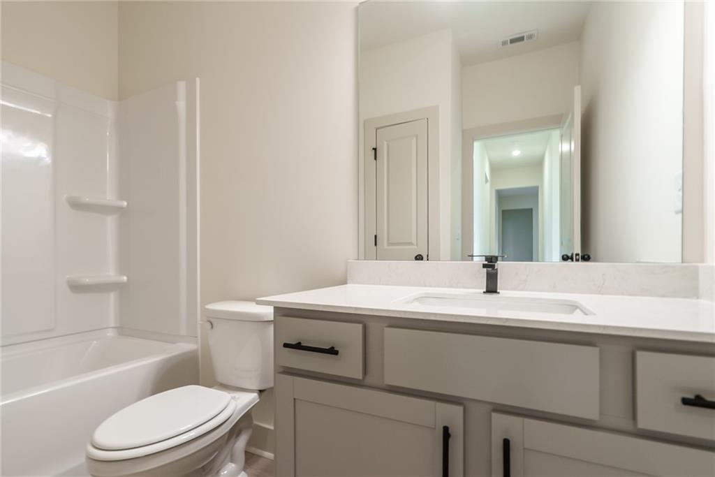 205 Squirrel Run Good Hope, GA 30641 - Photo 28 of 50 a bathroom with a sink toilet vanity and tub
