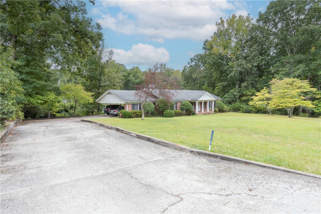 118 Blair Road Belton, SC 29627 - Photo 2 of 49 A long concrete driveway leads to this classic brick ranch home nestled among mature trees.