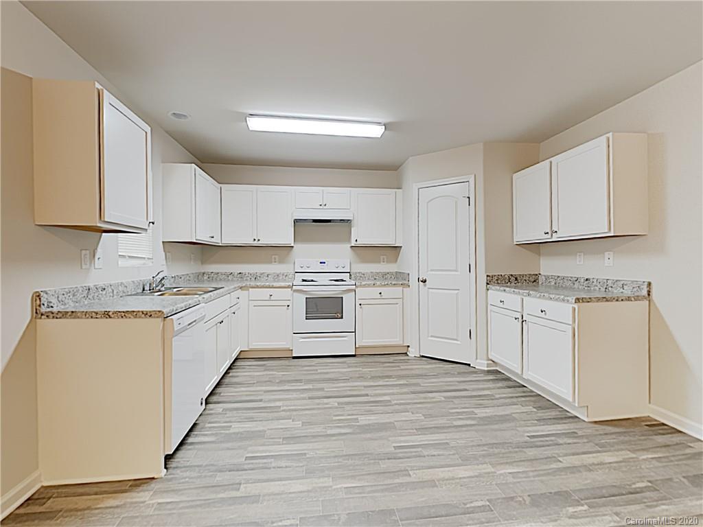 621 Buckskin Road Oakboro, NC 28129 - Photo 7 of 15 a kitchen with granite countertop white cabinets and white appliances