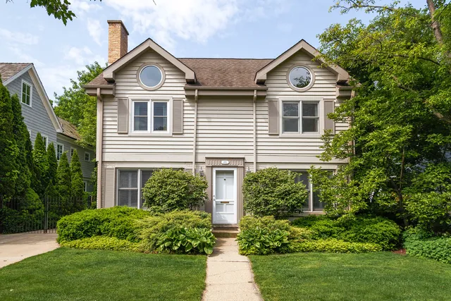 a front view of a house with a yard and trees