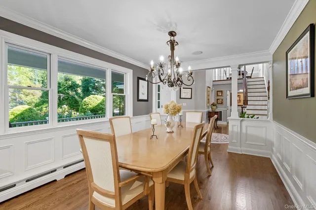a view of a dining room with furniture a chandelier and wooden floor