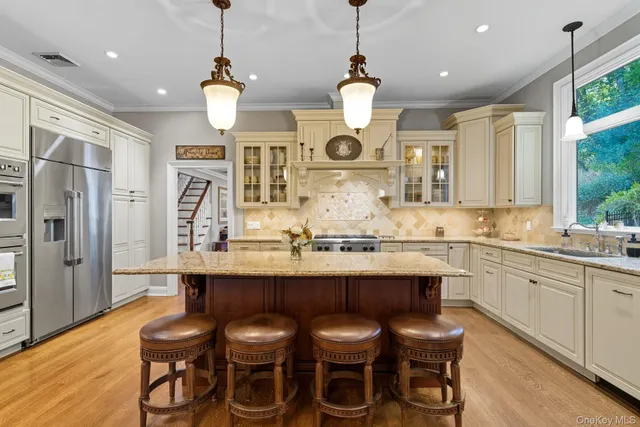 a kitchen with stainless steel appliances a dining table chairs and wooden floor