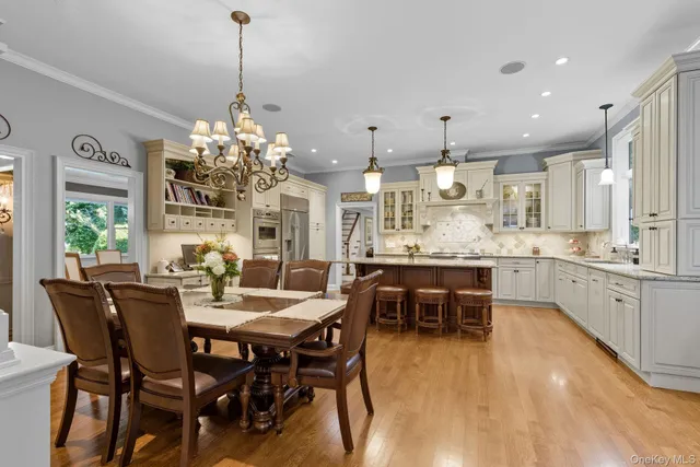 a dining room filled chandelier and kitchen view