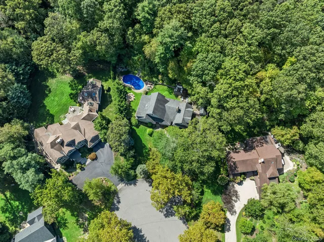 an aerial view of residential house with outdoor space and trees all around