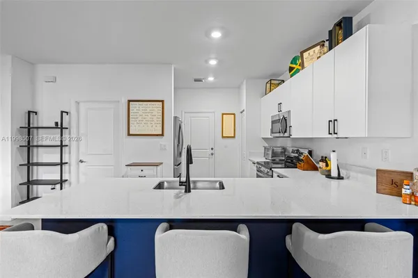 a room with a table chairs and white walls