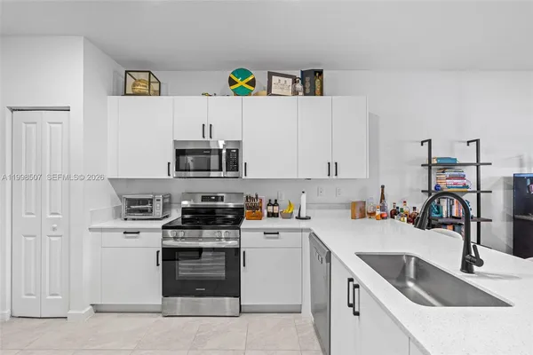 a kitchen with stainless steel appliances a sink stove and white refrigerator with wooden cabinets