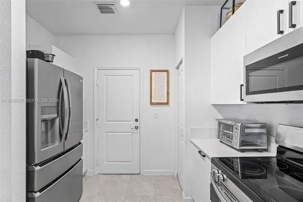 a kitchen with stainless steel appliances a refrigerator and a stove top oven