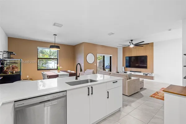 a room with sink cabinets and flat screen tv