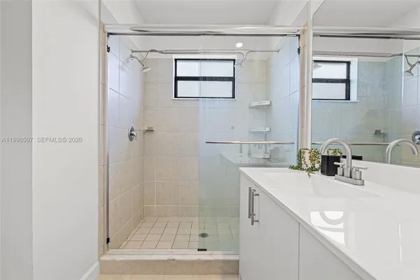 a bathroom with a sink a shower and a mirror