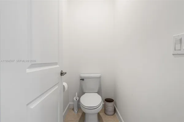 a white toilet sitting next to a white wall