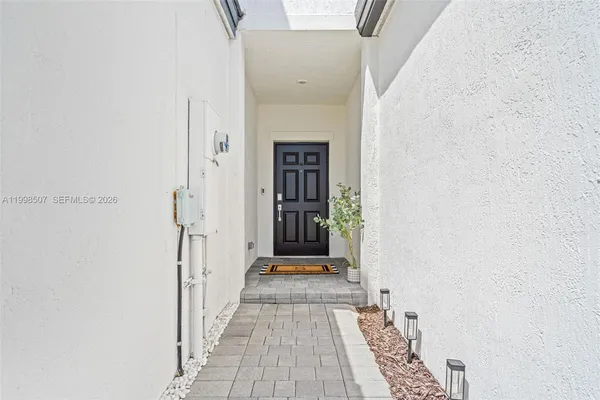 a view of a hallway with wooden floor and a bathroom