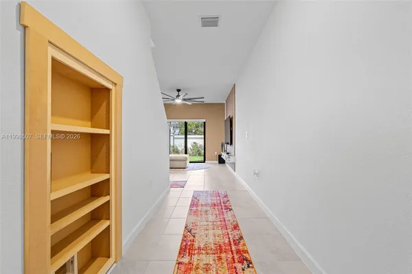 a view of a hallway with wooden floor and a bathroom