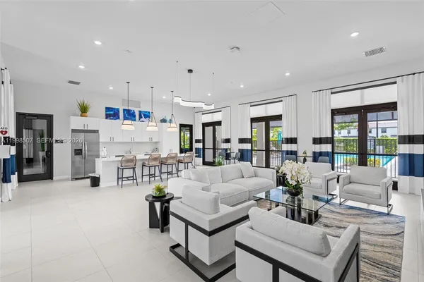 a large living room with stainless steel appliances granite countertop couches a fireplace a flat screen tv and a large window