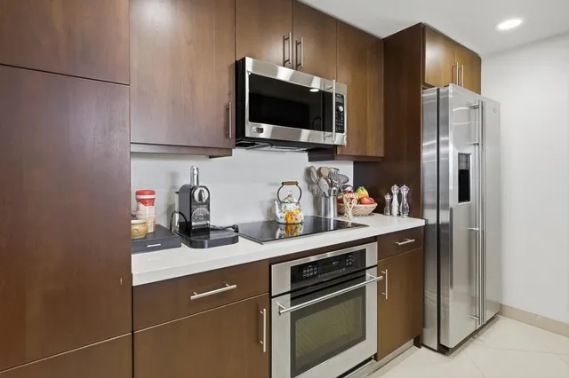 a kitchen with stainless steel appliances a sink stove refrigerator and cabinets