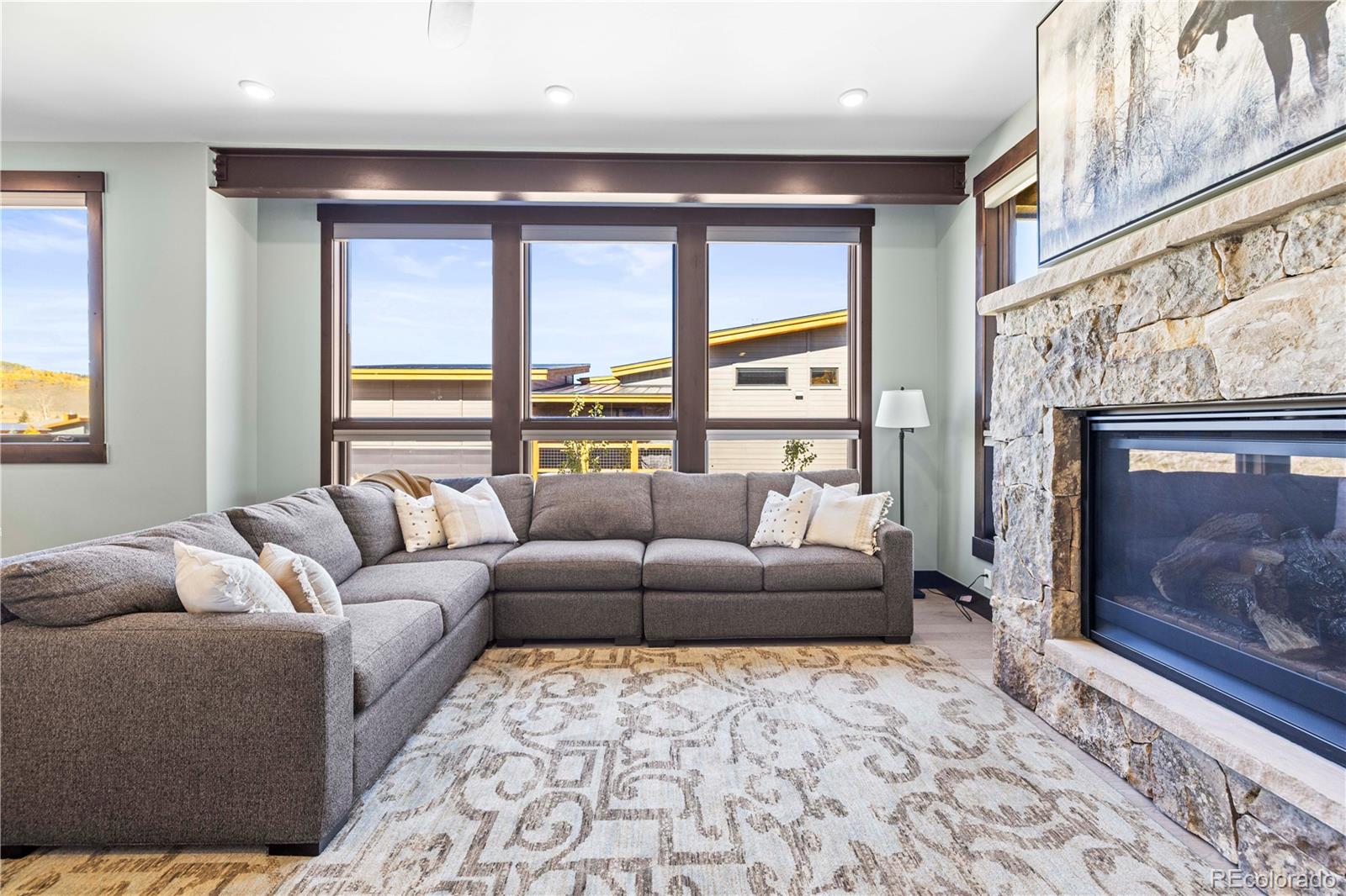 143 Beasley Road Silverthorne, CO 80498 - Photo 6 of 40 a living room with furniture a fireplace and a floor to ceiling window