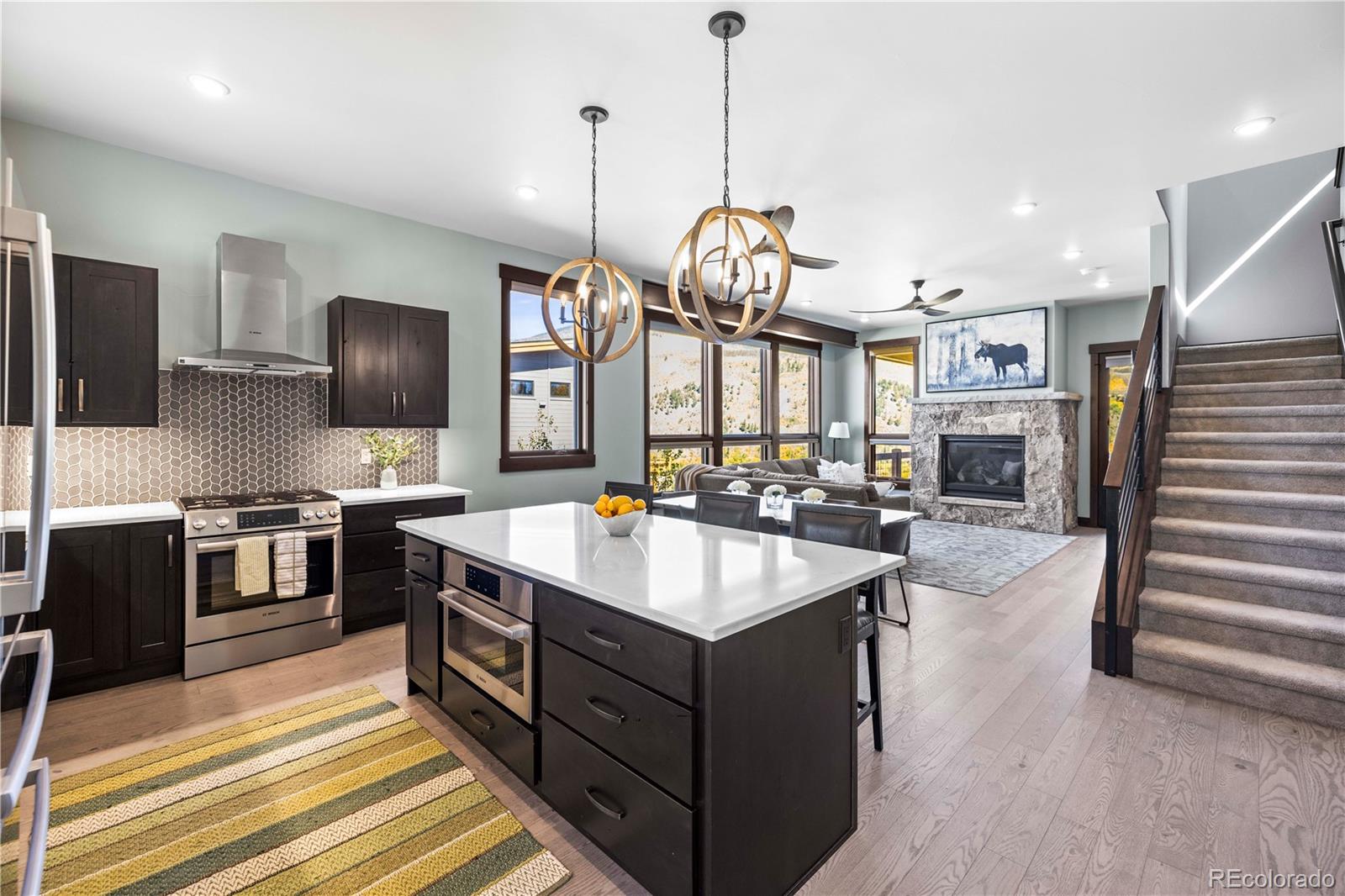 143 Beasley Road Silverthorne, CO 80498 - Photo 10 of 40 a kitchen with stainless steel appliances granite countertop a sink a stove and a wooden floor