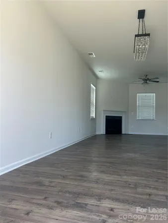a view of an empty room with a fireplace and a window