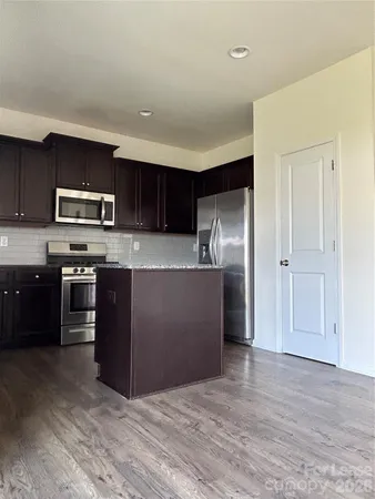 a kitchen with kitchen island a sink appliances and cabinets