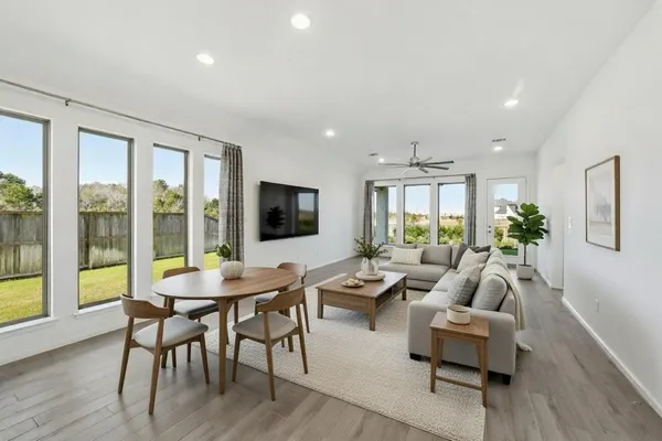 a living room with furniture a flat screen tv and a large window
