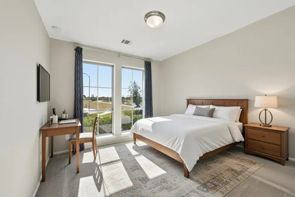 a bedroom with a large bed and a balcony view