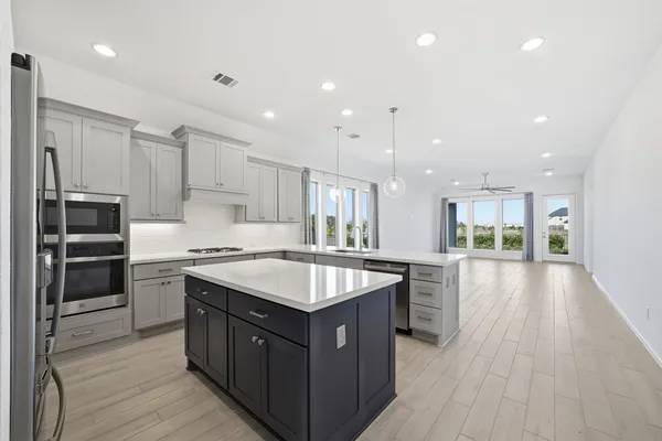 a large kitchen with stainless steel appliances granite countertop a stove and a sink