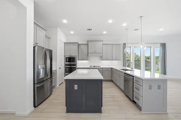 a large kitchen with stainless steel appliances kitchen island granite countertop a large counter top a sink stainless steel appliances and cabinets