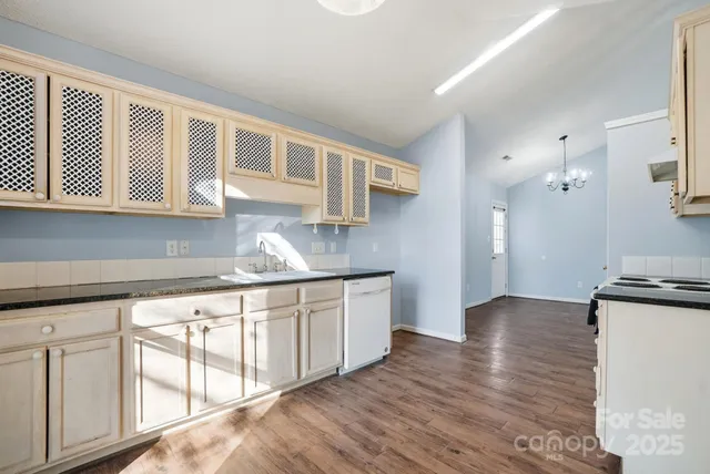 a kitchen with granite countertop white cabinets and white appliances