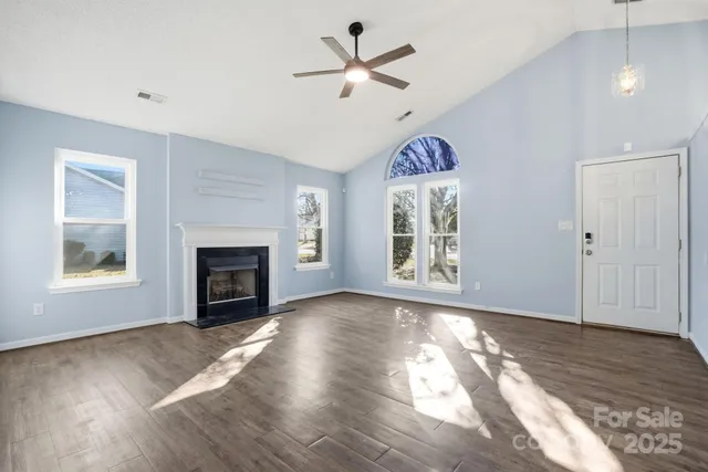 an empty room with windows and a fireplace
