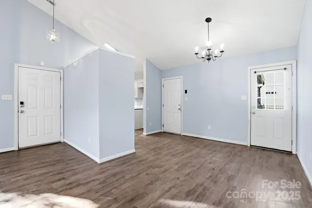 an empty room with wooden floor and ceiling fan